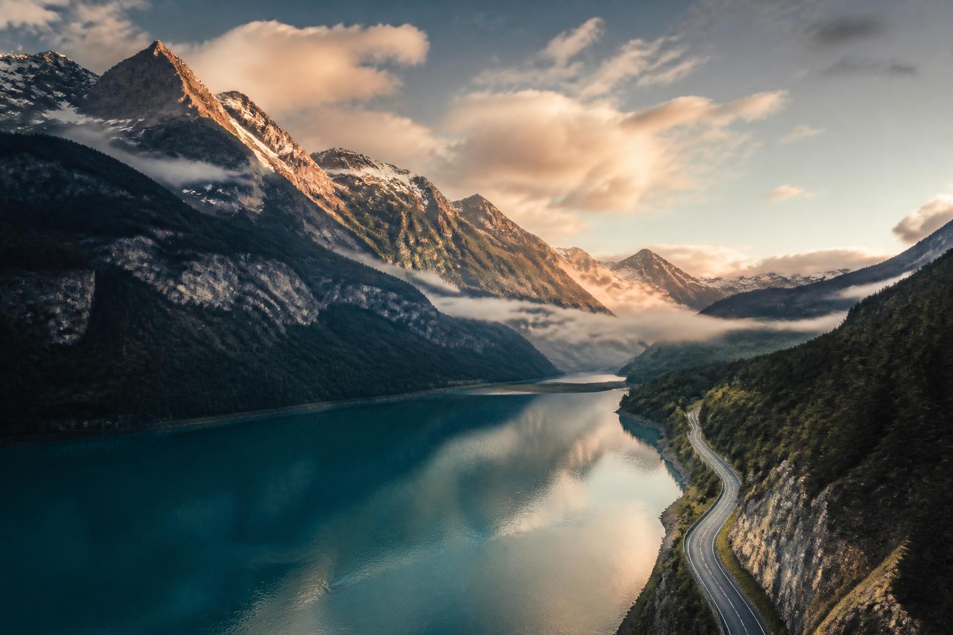 Paysage alpin suisse : lac turquoise et sommets enneigés au lever du jour